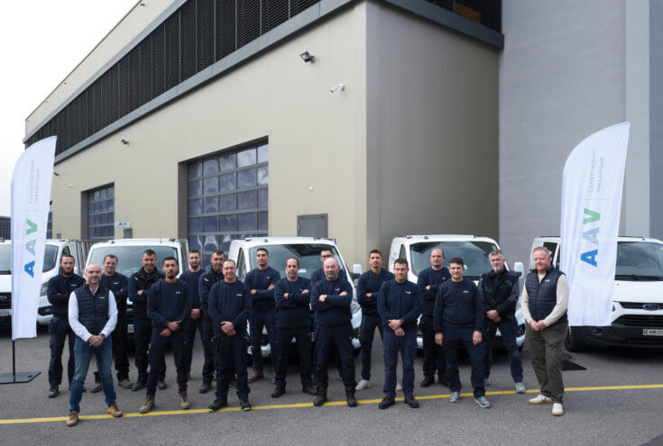 Équipe de montage AAV Contractors clarinettée devant les véhicules de chantier à Plan-les-Ouates